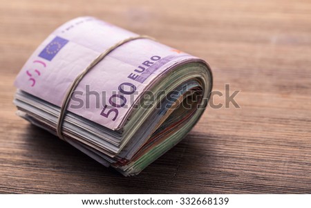 Close-up Rolled Euro Banknotes On Wooden table.