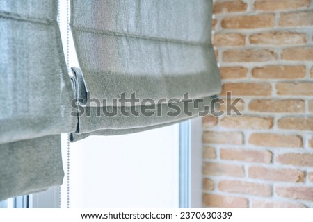 Close-up of roman blinds with gray linen fabric