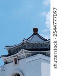 A close-up of the roof of the CKS Memorial Hall, with its blue tiles and white walls showing its delicate architectural beauty under the clear sky.