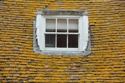 Closeup Of A Roof Covered With Moss And Old Dormer.