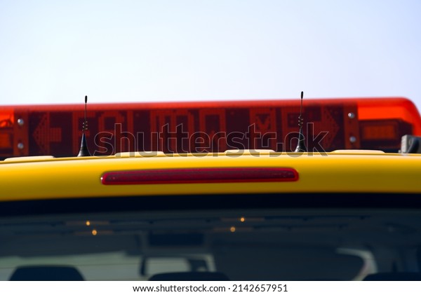 Close-up of roof\
top with follow me display of parked yellow van of airfield\
maintenance at Zürich Airport on a sunny spring day. Photo taken\
March 26th, 2022, Zurich,\
Switzerland.