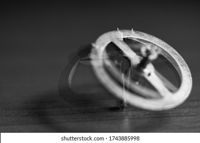 Close-up of a rotating gear from a clockwork on a table with shallow depth of field. Abstract composition. Movement, rotation, dynamics. Black and white photography