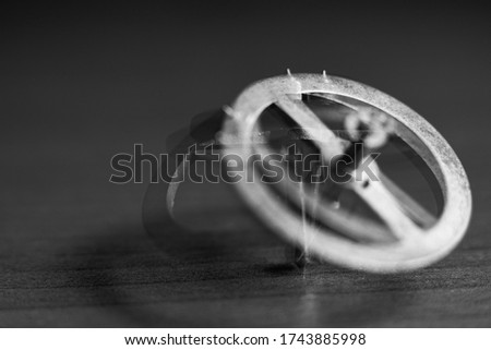 Close-up of a rotating gear from a clockwork on a table with shallow depth of field. Abstract composition. Movement, rotation, dynamics. Black and white photography