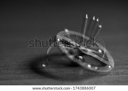 Close-up of a rotating gear from a clockwork on a table with shallow depth of field. Abstract composition. Movement, rotation, dynamics. Black and white photography