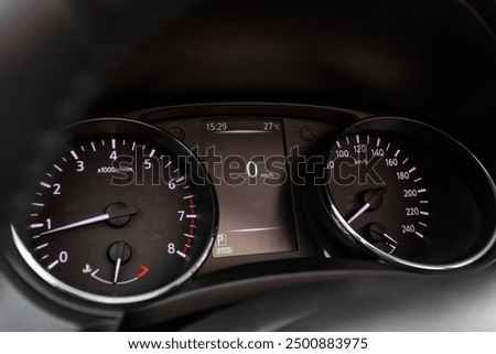 Close-up of round dashboard, speedometer and tachometer with white backlight. modern car interior