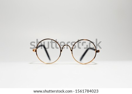 Close-up of round gold eyeglasses isolated on white.