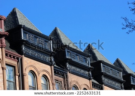 Close-up of a row of pyramid-shaped black roofs on historic row houses in the landmarked Dorrance Brooks Square Historic District in Harlem, New York City, USA