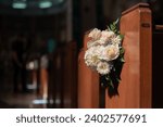 A close-up of a row of wooden pews in a church, adorned with a colorful display of flowers