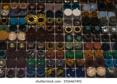 A Close-up Of Rows Of Ear Gauges Or Plugs At A Piercing And Tattoo Convention