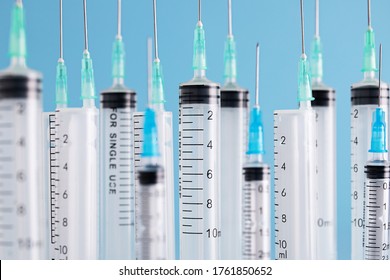 A closeup of rows of syringes over a blue background. Vaccine, COVID-19, coronavirus concept