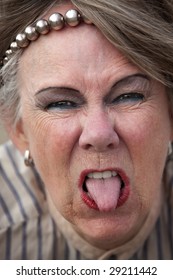 Closeup Of Rude Old Woman Sticking Out Her Tongue