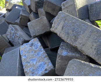 Close-up of a rugged pile of grey rectangular stone blocks at a construction site. Raw texture and industrial aesthetic, perfect for building and masonry themes.