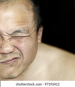 A Closeup Of A Rugged Sun Tanned Oriental Man Face Grimacing.