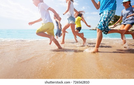 Close-up Of Running Kids Legs In Shallow Sea Water