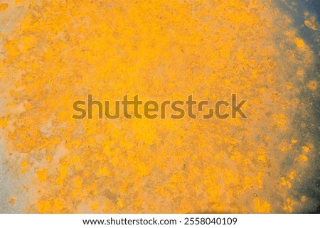 Close-up of a rusted and decayed metal surface. The effects of oxidation are visible in shades of light orange, brown, yellow, and white.