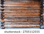 Close-up of a rustic log cabin wall with warm wood tones and weathered texture