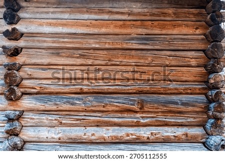 Close-up of a rustic log cabin wall with warm wood tones and weathered texture
