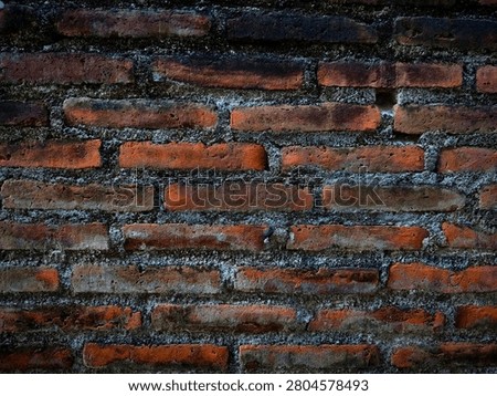 Close-up of rustic red brick wall texture with dark vignetting and aged mortar