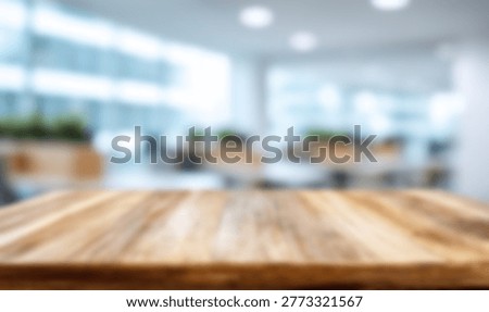 A close-up of a rustic wooden table in the foreground, with a blurred background of a contemporary office space.