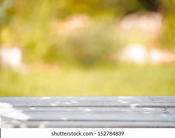 Close-up of a rustic wooden table on a green blurred background - Powered by Shutterstock