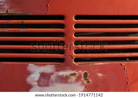 Closeup of rusty aged red car vents retro style old vw beetle rear peeled bright red paint