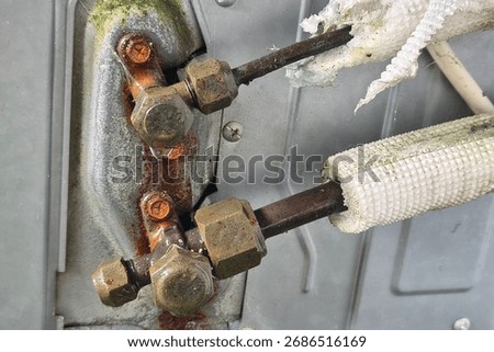 Close-up of rusty, corroded AC unit service valves and refrigerant lines with damaged, dirty insulation, highlighting a need for HVAC repair, maintenance, and system service.