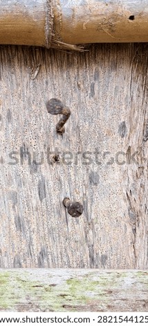 Close-up of rusty nails on weathered wood highlighting corrosion, aged texture, and rustic construction details.