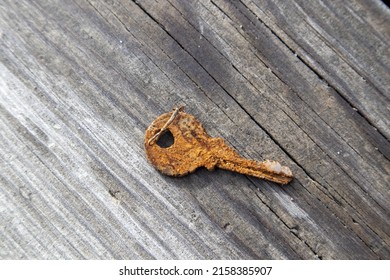 A Closeup Of A Rusty Old Key On The Wooden Board