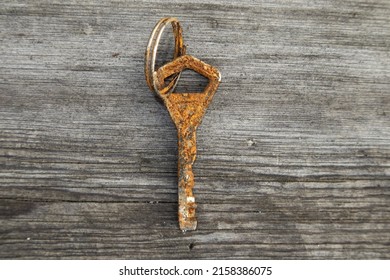 A Closeup Of A Rusty Old Key On The Wooden Board