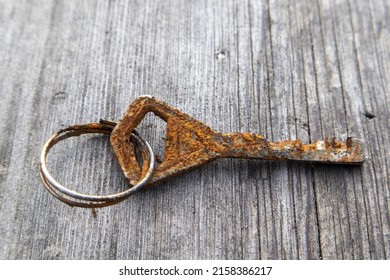 A Closeup Of A Rusty Old Key On The Wooden Board