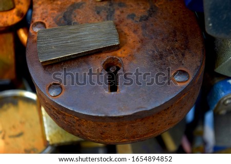 Closeup of a rusty padlock on a gate in a touristy city. Metal rusted lock with missing key. Great concept for keeping secret, door keeper and security