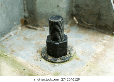 Close-up of a rusty threaded bolt with a hex nut fixed to a weathered metal surface, industrial hardware detail with corrosion and grime, shallow depth of field.
