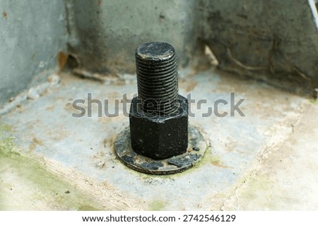 Close-up of a rusty threaded bolt with a hex nut fixed to a weathered metal surface, industrial hardware detail with corrosion and grime, shallow depth of field.