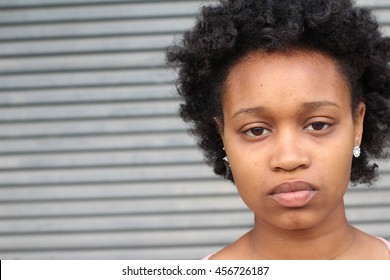 Close-up of a sad and depressed African woman deep in thought outdoors.