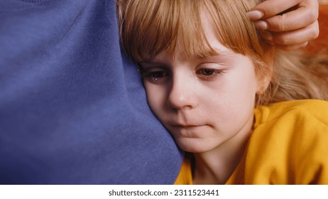 Close-up of sad girl kid is crying and lying on mother at home. Violence against children in family. Quarrel, bullying at school. Child toddler abuse. Mom hugs, embrace, takes pity on her daughter - Powered by Shutterstock