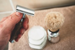 Close-up Of Safety Razor 50s Style And Male Cosmetic Products And Supplies Used By Men To Shave. Safety Razor, Shaving Brush And Foam On Beige Towel Background. Eco Friendly Tools For Men Shaving.