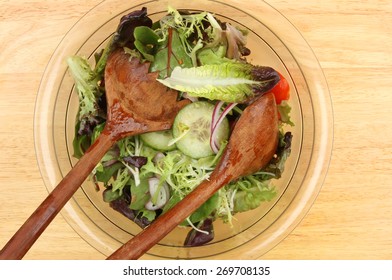 Closeup of a salad in a bowl with wooden salad servers - Powered by Shutterstock