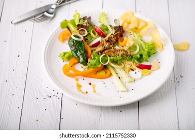 A Closeup Of Salada Gourmet With Chicken Strips Salad On A White Ceramic Plate