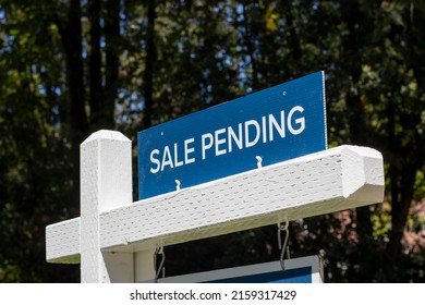 Closeup of a "Sale Pending" real estate sign outside a residential single-family house on the market. Pandemic housing market frenzy concept. - Shutterstock ID 2159317429