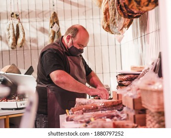 A Closeup Of A Salesman Wearing A Mask Packing Meat In A Stor