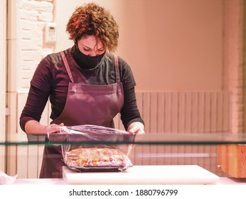 A Closeup Of A Saleswoman Packing Meat In Cellophane In The Store