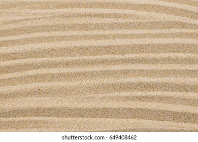 closeup of sand pattern of a beach in the summer for background