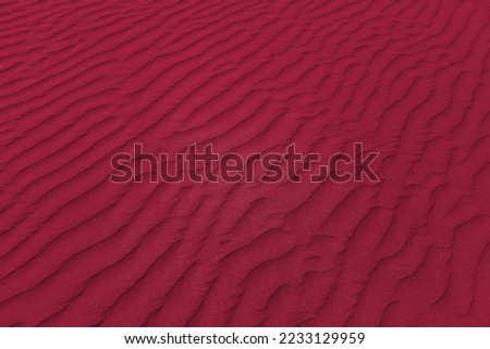 closeup of sand pattern of a beach in the summer. New 2023 trending PANTONE 18-1750 Viva Magenta color

