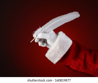 Closeup of Santa Claus holding a quill pen. Horizontal format on a light to dark red spot background. - Powered by Shutterstock