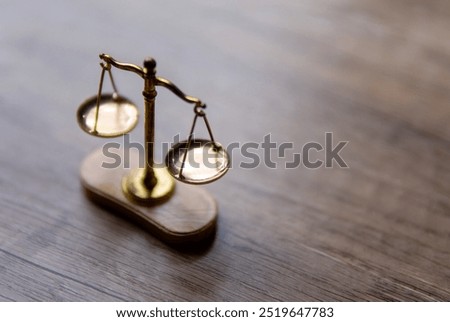 A close-up of a scale with two balanced plates on a wooden table. Copy space for text. Balance, justice, and fairness concept.