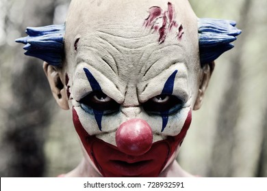 Closeup Of A Scary Evil Clown With A Disturbing Look In His Eyes In The Woods