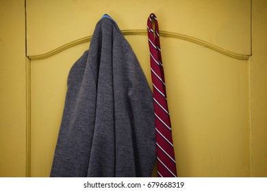 Close-up of school uniform hanging on yellow door - Powered by Shutterstock