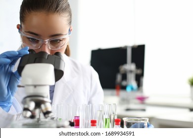 Close-up of scientist using microscope and test tubes. Laboratory assistant making analysing sample of medicines in research lab. Chemical experiments concept