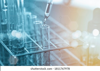 Closeup Of Scientists Use A Chemical Dropper Into A Test Tube During An Experiment In A Science Laboratory.