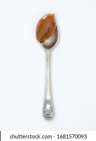 Closeup Of Scoop Full Of Dulce De Leche  Or Milk Caramel Spread On White Background